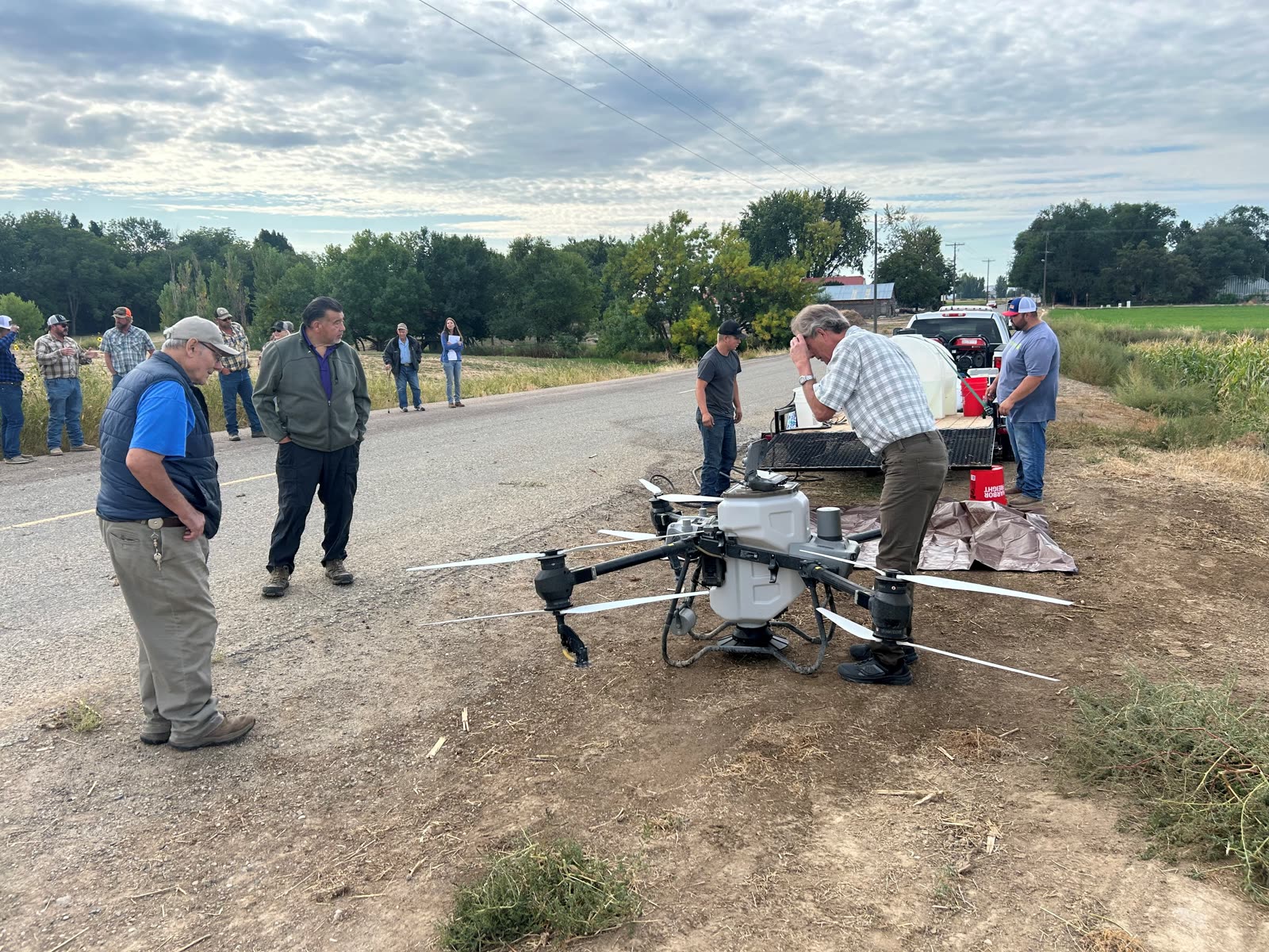 Attendees gathered around an agricultural seeding drone at the 2025 fall tour demonstration