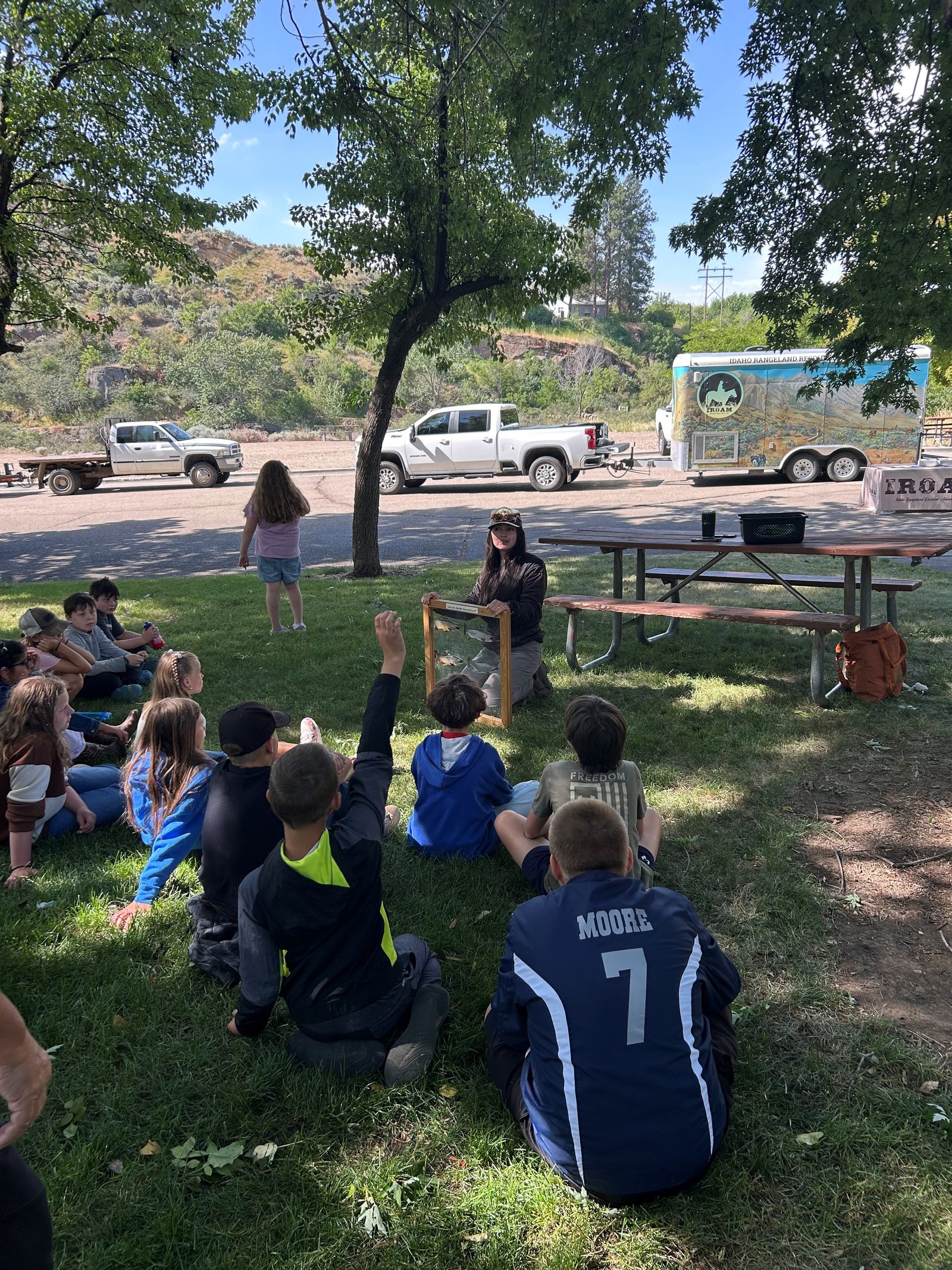 Students learning about fisheries beside the water at outdoor school
