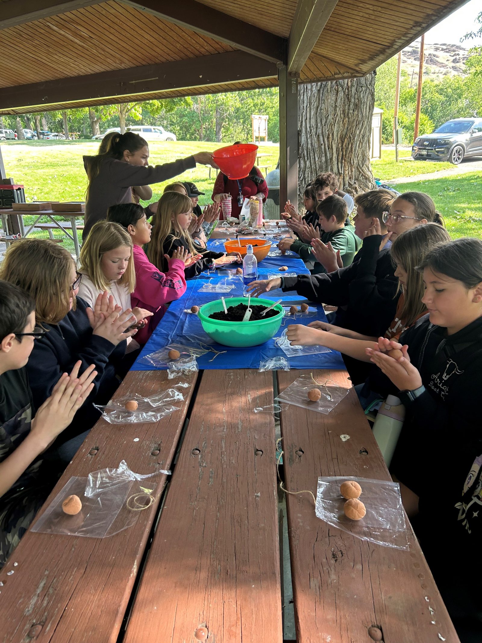 Students making pollinator seed pods at outdoor school
